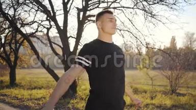 一个英俊的白种人男孩在秋天公园的跳绳锻炼<strong>日</strong>落。 户外运动服装培训<strong>青年</strong>